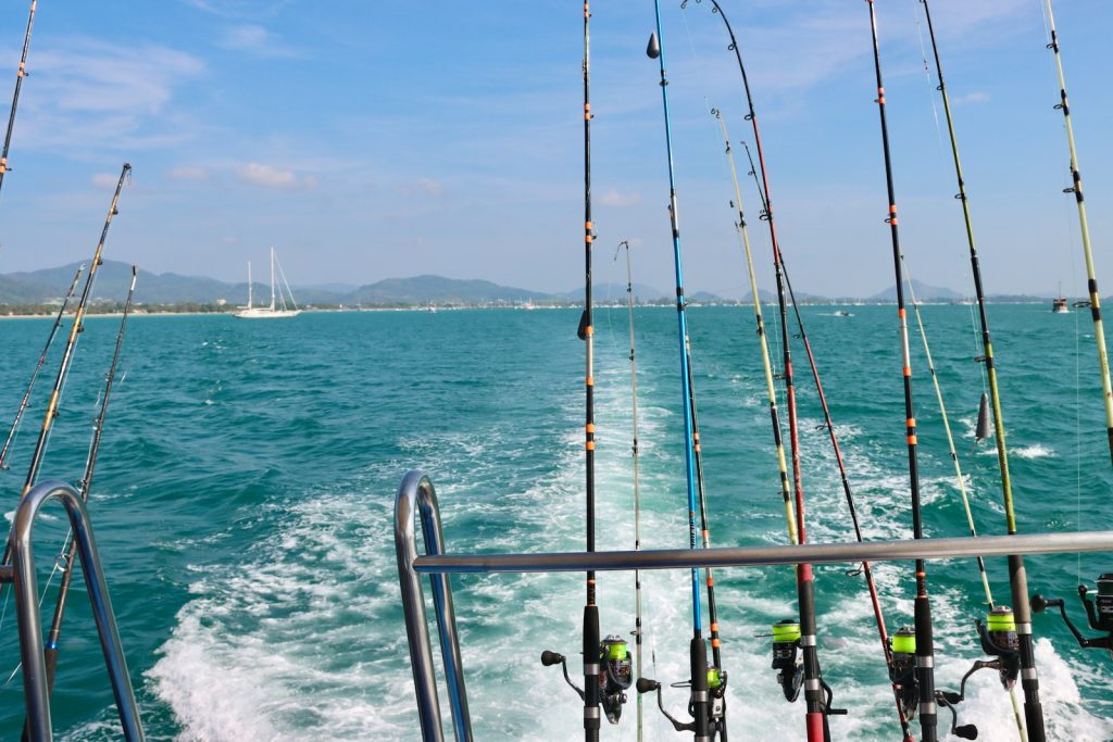 a bunch of fishing rods on a boat in the water